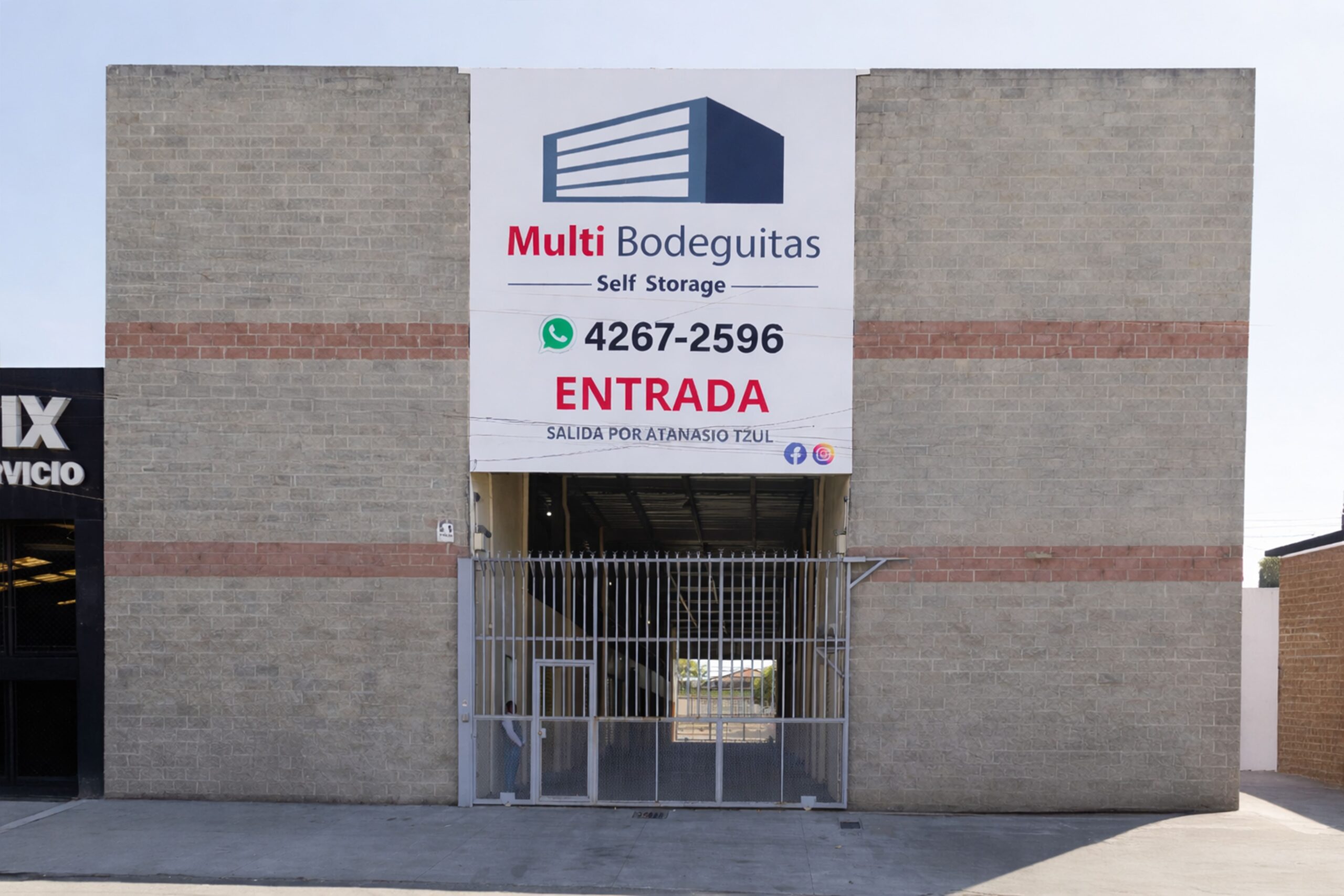 Fachada de complejo de bodeguitas con parqueo para clientes.